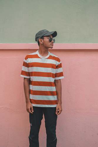 human man looking over shoulder near pink wall people