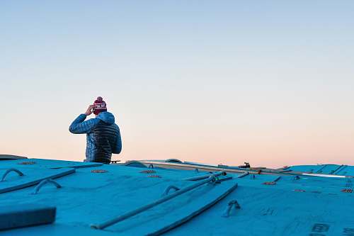 people man scratching head on roof top under white sky human