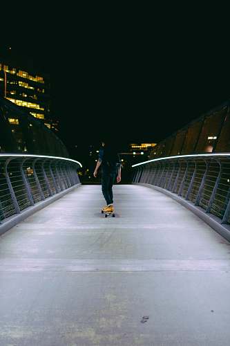 night man skating on gray concrete road bridge