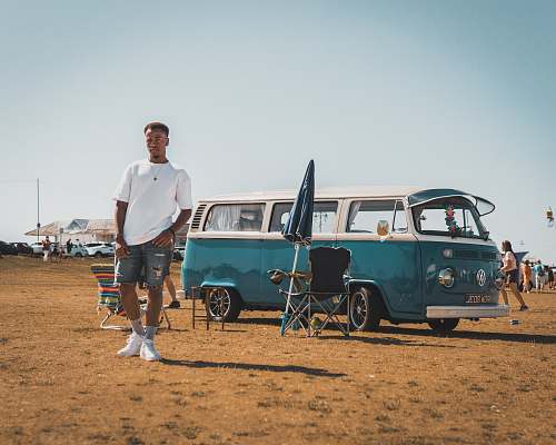 human man standing beside Volkswagen T2 van