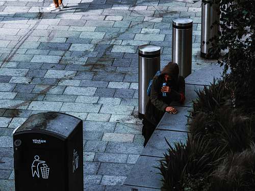 people man standing near black trash bin human