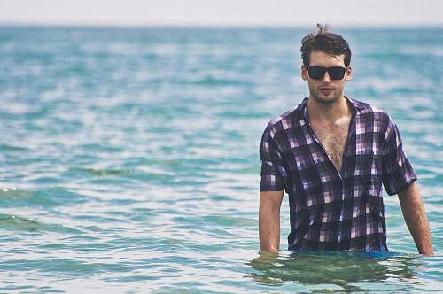 human man standing on body of water during daytime people