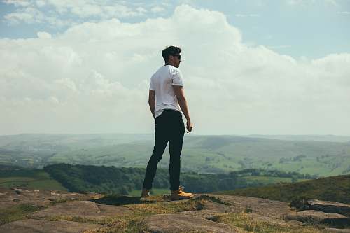people man standing on bolder overlooking the hills and mountains human