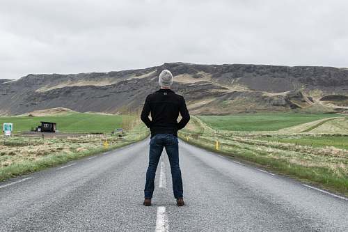 human man standing on road road