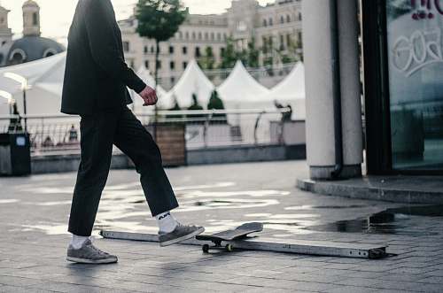 human man stepping on skateboard people