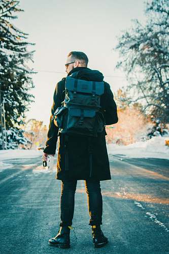 human man wearing backpack in middle of the road people