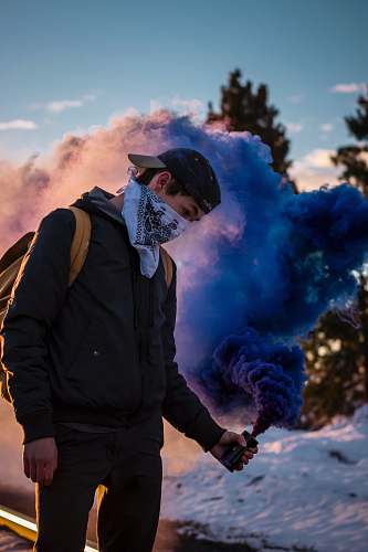 people man wearing bandana holding blue smoke can standing human