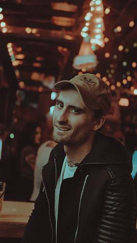 people man wearing black jacket smiling inside brown room human