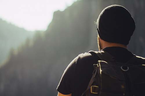 people man wearing black t-shirt and knit cap fronting mountains man