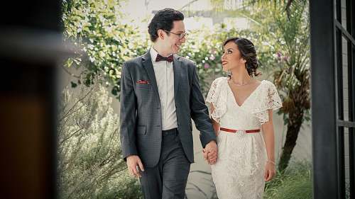 people man wearing gray suit jacket holding woman's hand human