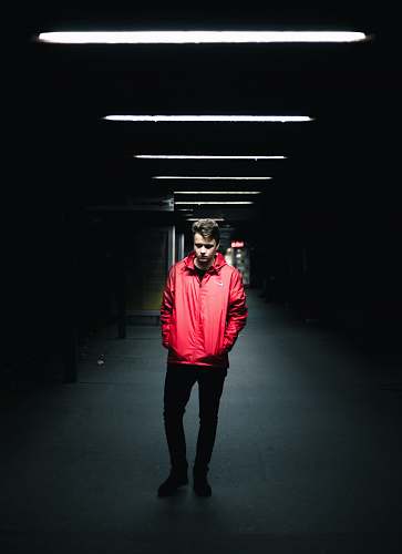 people man wearing red leather jacket standing inside dark area human
