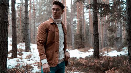 people man wearing white turtleneck sweater with brown jacket while standing in forest human