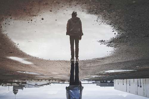 human man's reflection on body of water photography people