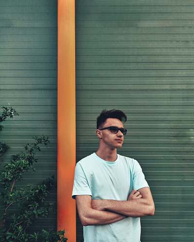 human men's white crew-neck T-shirt standing beside orange post people
