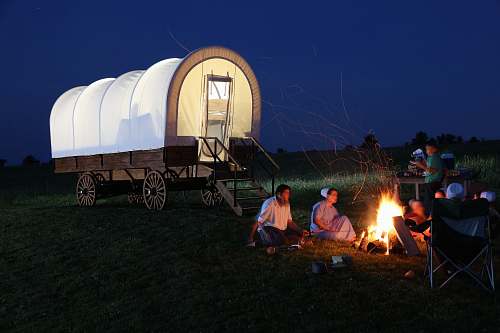 campfire people outside of camper wagon camping
