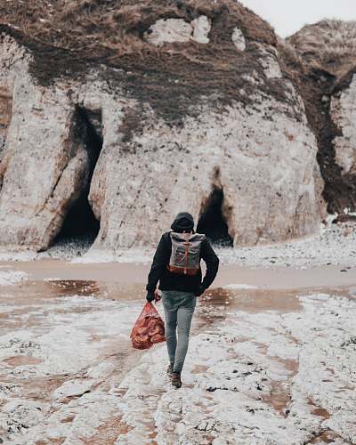 people person black shirt with backpack walking on seashore human