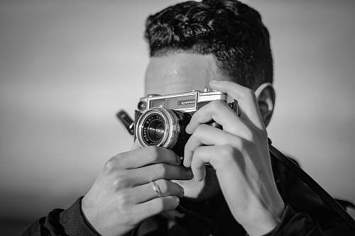 people person holding SLR camera black-and-white