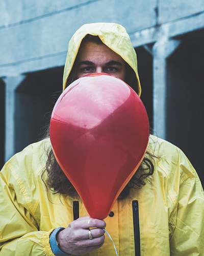 human person on raincoat holding red balloon people