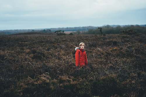 human person standing in the middle of green plants people