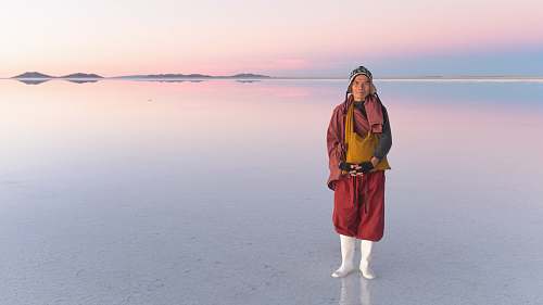 human person standing on body of water during daytime people