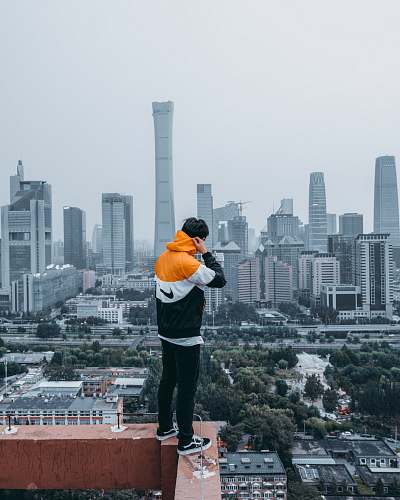 people person standing on cliff wall during daytime human