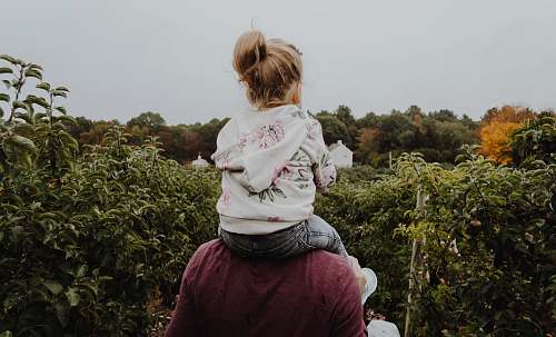 people photo of girl riding on person shoulder human