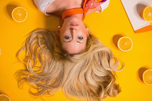 people photo of woman leaning on yellow surface blonde