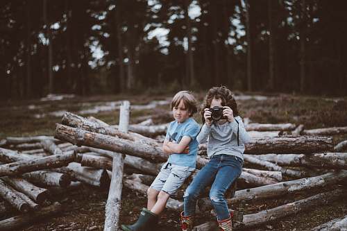 human selective focus photography of boy and girl sitting on log people