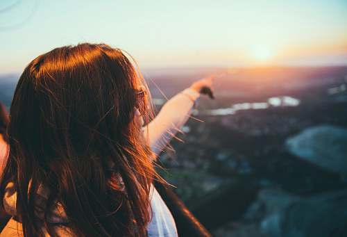 people selective focus photography of woman pointing on sky human