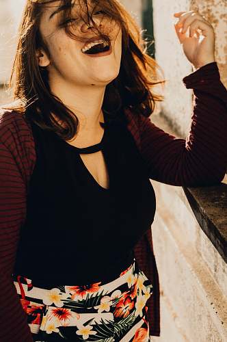 people smiling woman wearing keyhole-neckline top and floral skirt human