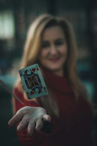 human time lapse photo of queen of hearts playing card near woman's palm people