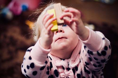 people toddler playing with two wooden blocks human