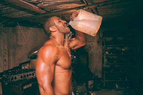 people topless man drinking water from plastic container fitness