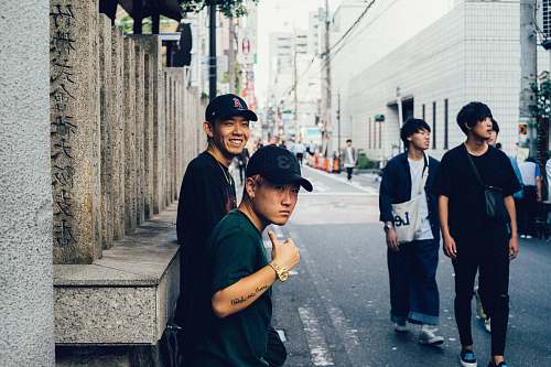 human two men in black shirts leaning on wall people