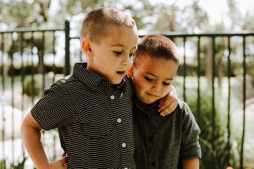 human two toddlers standing near black metal railing people