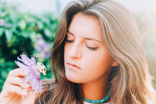 woman woman holding flower during daytime in selective focus photography girl