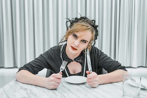 human woman holding fork and knife inside room people