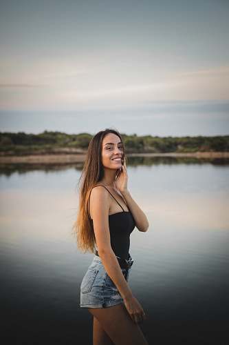 human woman in black spaghetti strap top and blue denim shorts people