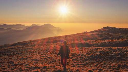 people woman in blue jacket walking on desert during sunset nature