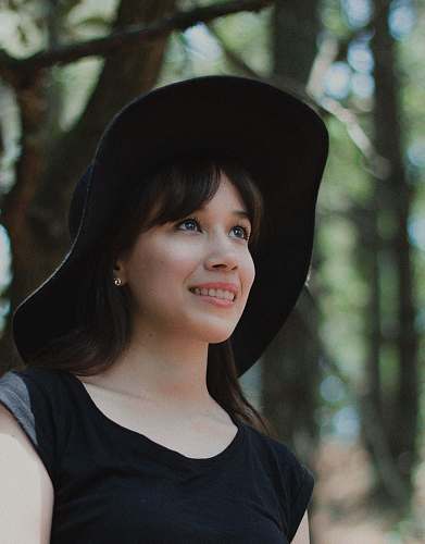 human woman looking up surrounded by trees people