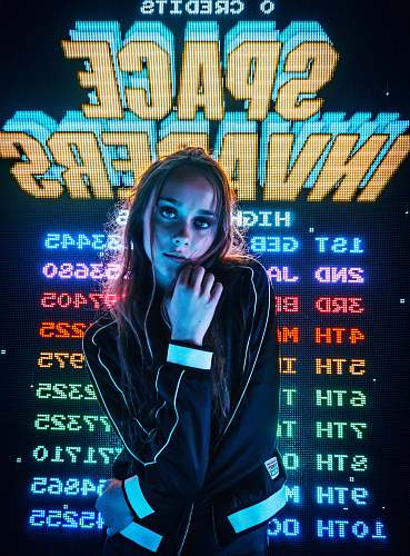 people woman posing for photo in front of Space Invaders scoreboard human