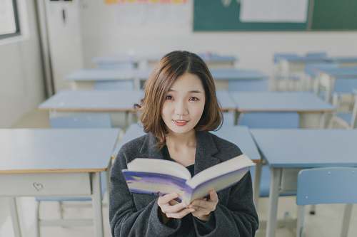 human woman reading book sitting on chair in room people