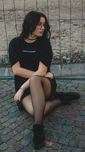 people woman sitting beside black fence human