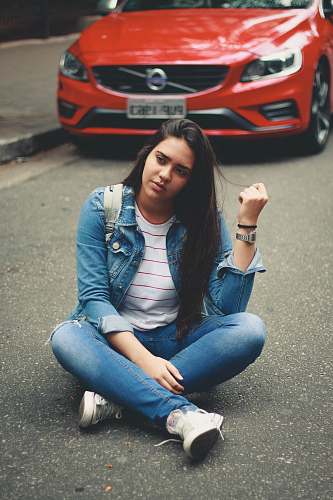 people woman sitting on road near red Volvo car human