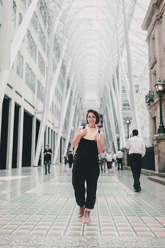 human woman standing at white concrete building during daytime people