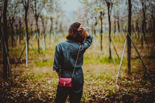 human woman standing between trees during daytime people