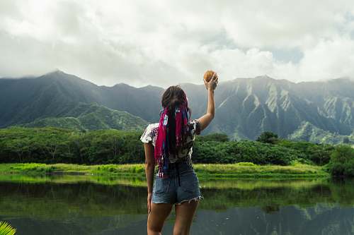 human woman standing facing green thick forest during daytime people