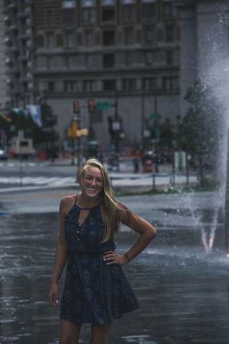 human woman standing in front of outdoor fountain people