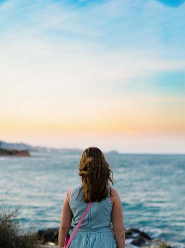 human woman standing near body of water people