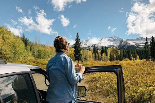 people woman standing near gray vehicle human